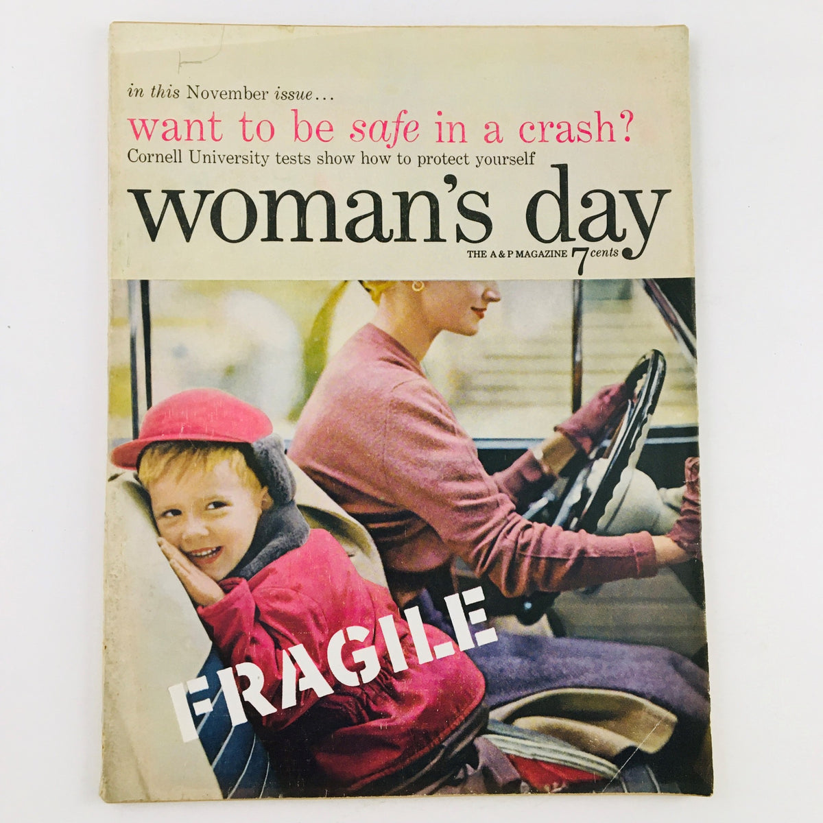 Cover of Woman's Day Magazine November 1954 featuring a young boy in a red hat smiling next to a woman driving, highlighting the vintage charm of the publication.