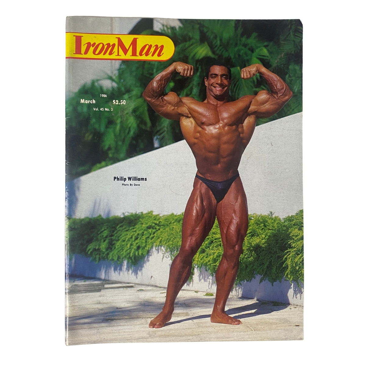 IronMan Magazine March 1986 featuring Phil Williams on the cover, showcasing a muscular bodybuilder posing confidently against a lush green backdrop.