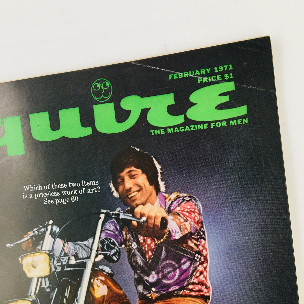 Cover of VTG Esquire Magazine February 1971 featuring bold green title and an image of a smiling man on a motorcycle, highlighting the issue's theme 'Sissy Bars Will Be Lower This Year'.