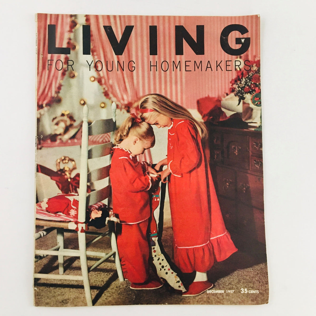 Cover of Living For Young Homemakers December 1957 magazine featuring two young girls in matching red pajamas, surrounded by a festive Christmas setting.