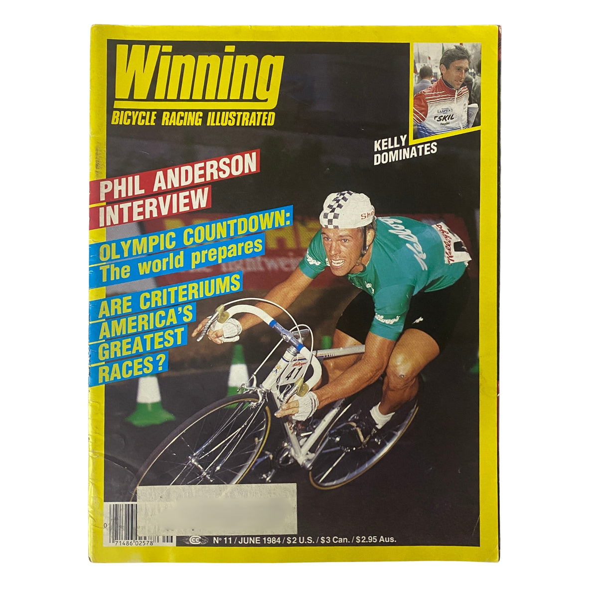 Cover of Winning Bicycle Racing Illustrated, June 1984, No. 11 featuring Phil Anderson, with a bold headline about Olympic countdown and Criterium racing.