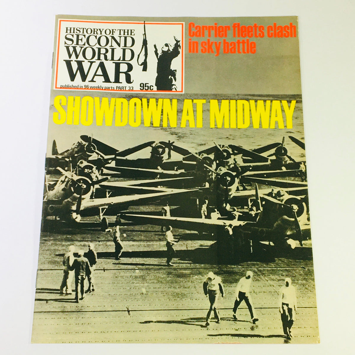 Cover of the vintage magazine 'History of the Second World War Part 33 - Showdown Battle of Midway', featuring a black and white image of aircraft on a carrier deck with a bold yellow title, capturing a pivotal moment in naval history.