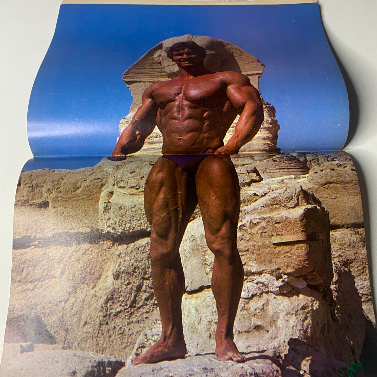 Color centerfold from Muscle & Bodybuilder Magazine July 1983, depicting Lance Dreher in a powerful pose against a historical backdrop, emphasizing bodybuilding excellence.