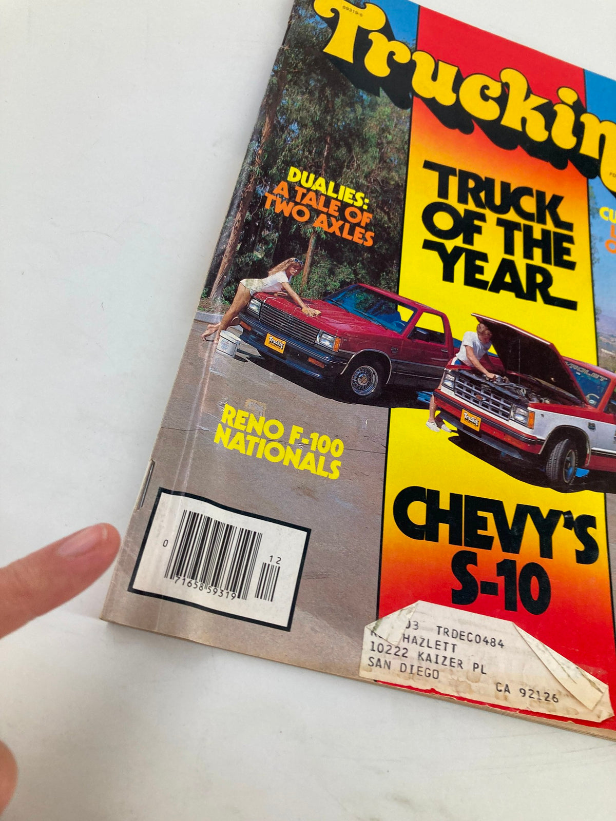 Detailed view of the VTG Truckin Magazine December 1982 cover showcasing the titles 'Truck of the Year' and 'Dualies: A Tale of Two Axles' along with imagery of Chevy trucks from the Reno F-100 Nationals.