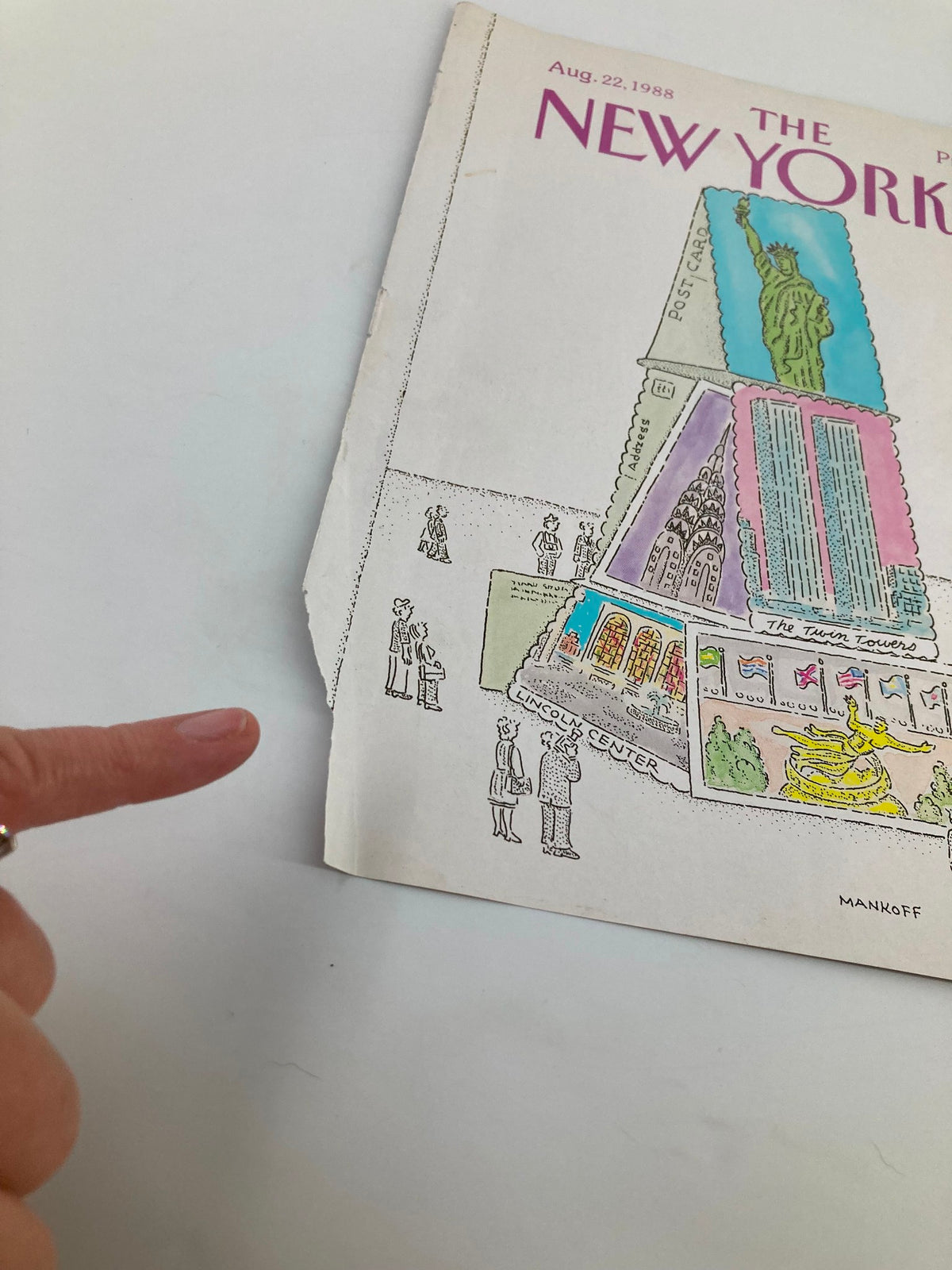 Detail of The New Yorker cover from August 22, 1988, 'Tower of Post Cards' by Robert Mankoff, emphasizing the illustration showing New York City elements and a finger pointing at the artwork.