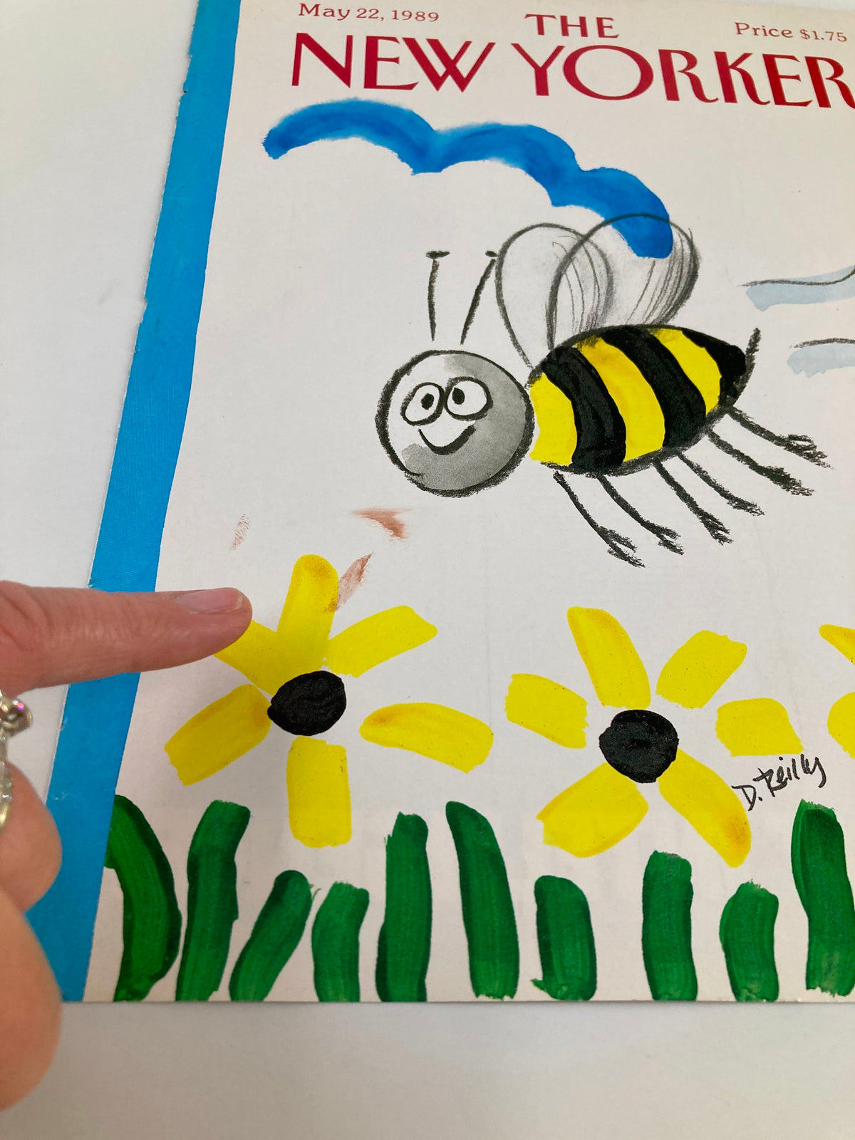 Close-up of the COVER ONLY The New Yorker May 22 1989 Bumble Bee by Donald Reilly, highlighting details of the bumblebee and flowers, with a finger pointing at the flower.
