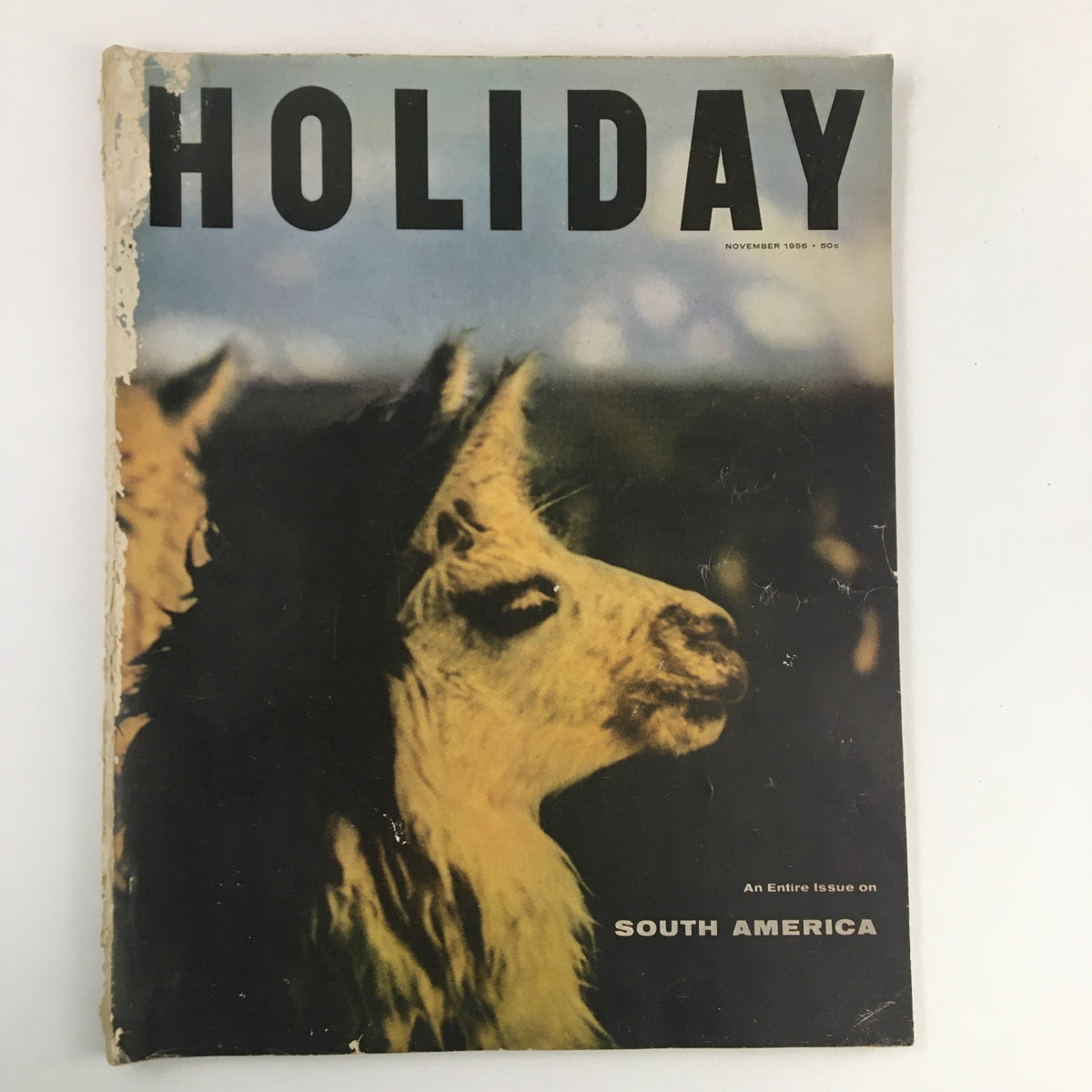Cover of Holiday Magazine November 1956 featuring the Illama, often known as the 'Camel of the Andes,' showcasing vibrant colors and mid-20th-century design.