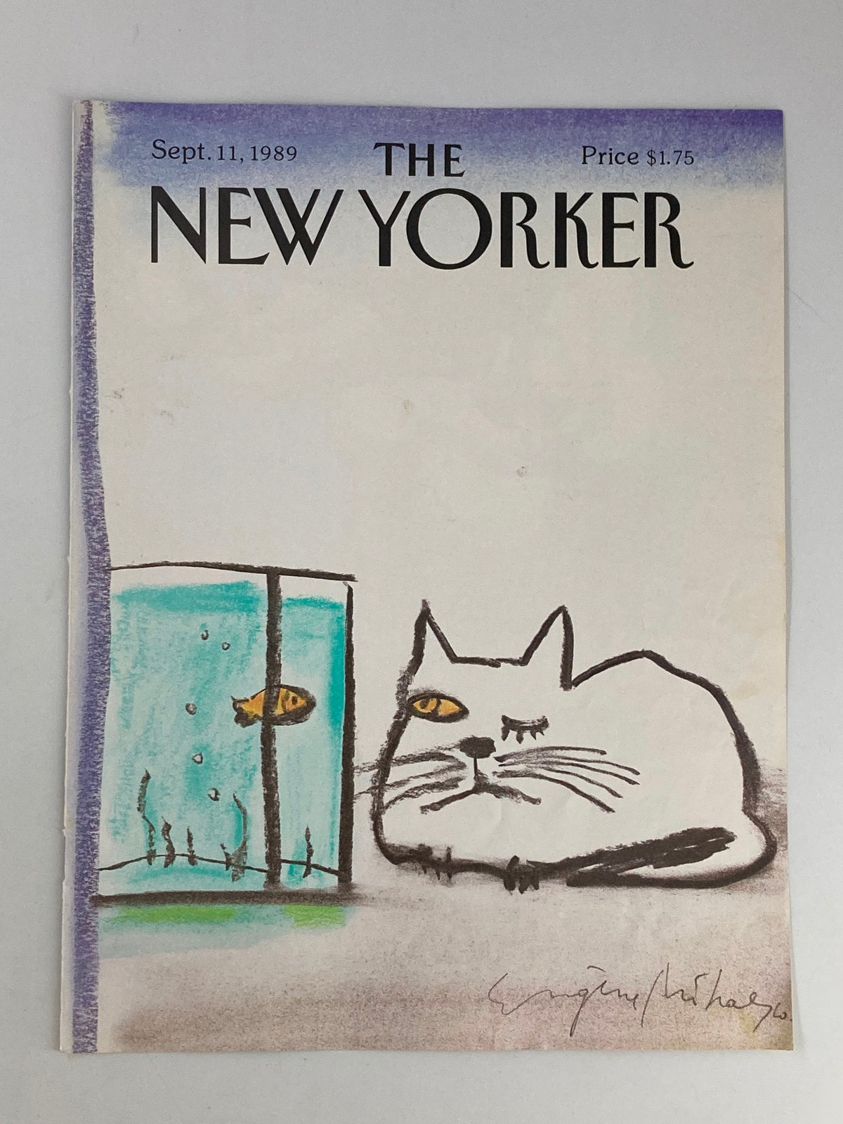 A close-up view of The New Yorker cover from September 11, 1989, illustrating a playful cat gazing at a fish in an aquarium, drawn by Eugene Mihaesco.