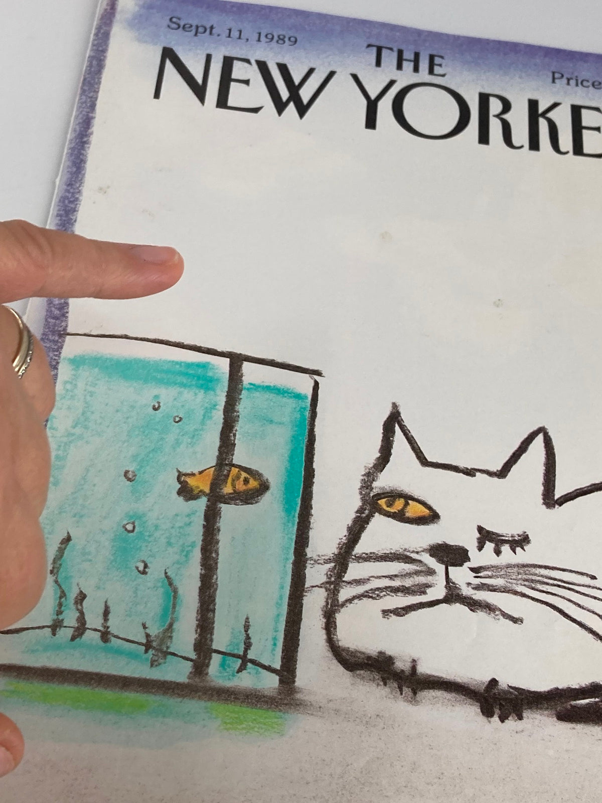 Detailed view of The New Yorker cover dated September 11, 1989, highlighting the cat and fish illustration by Eugene Mihaesco, with a finger pointing at the artwork for emphasis.