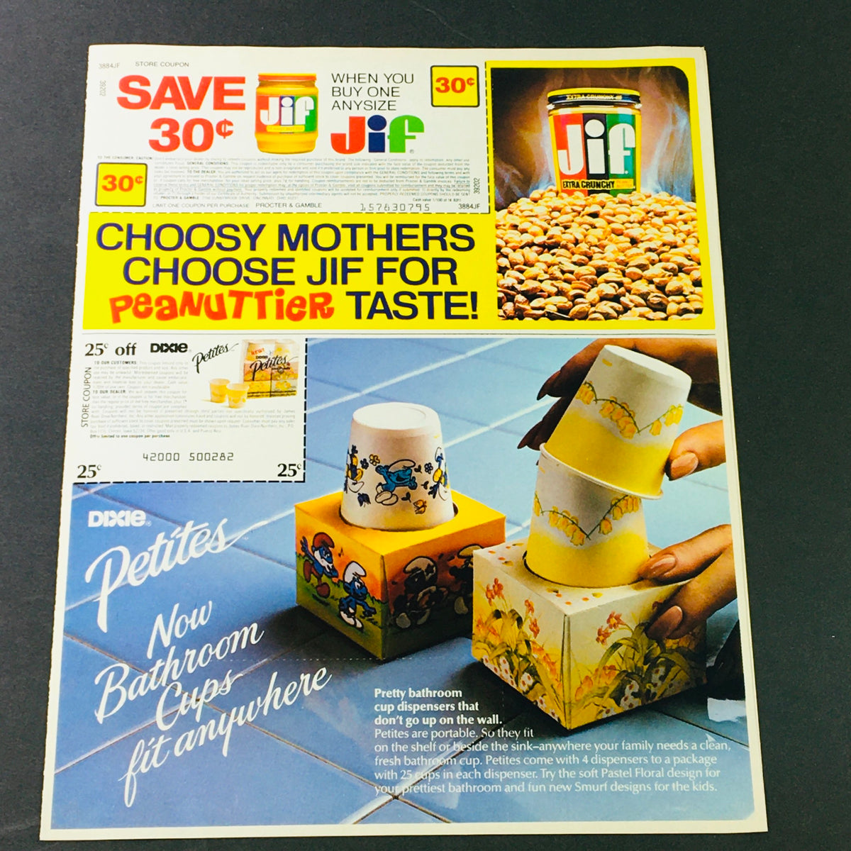 Vintage advertisement for Jif Peanut Butter and Dixie Petites cups from 1983. Highlights savings on Jif and showcases creative bathroom cup dispensers. A nostalgic collectible for fans of retro advertising.