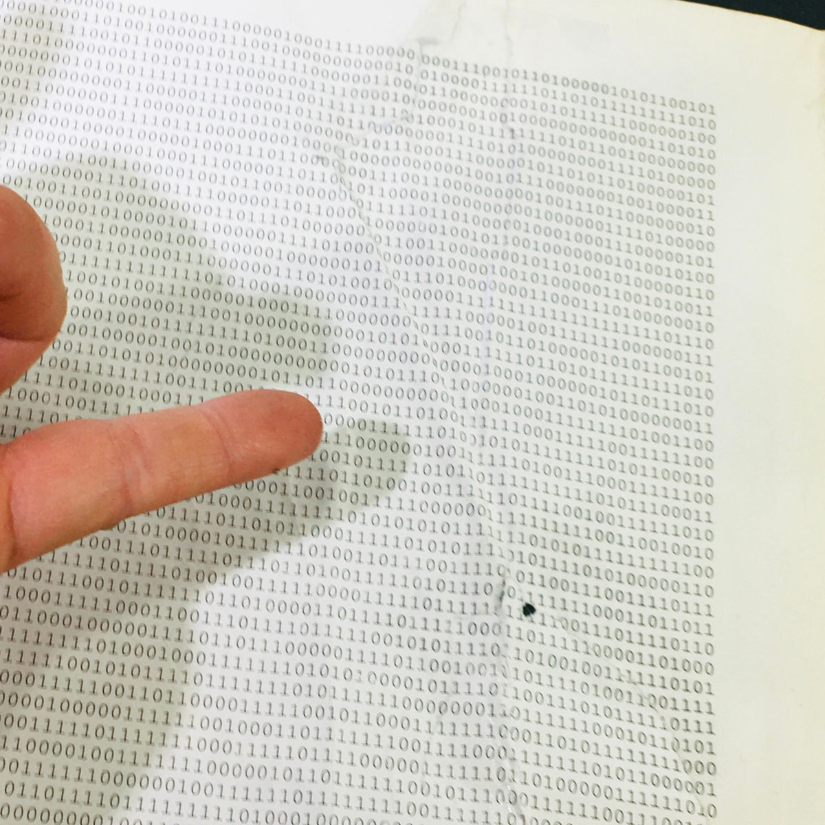 Detailed view of the back cover of Keyboard Magazine January 1996, showcasing binary text and a finger pointing at a crease, emphasizing wear on the vintage magazine.