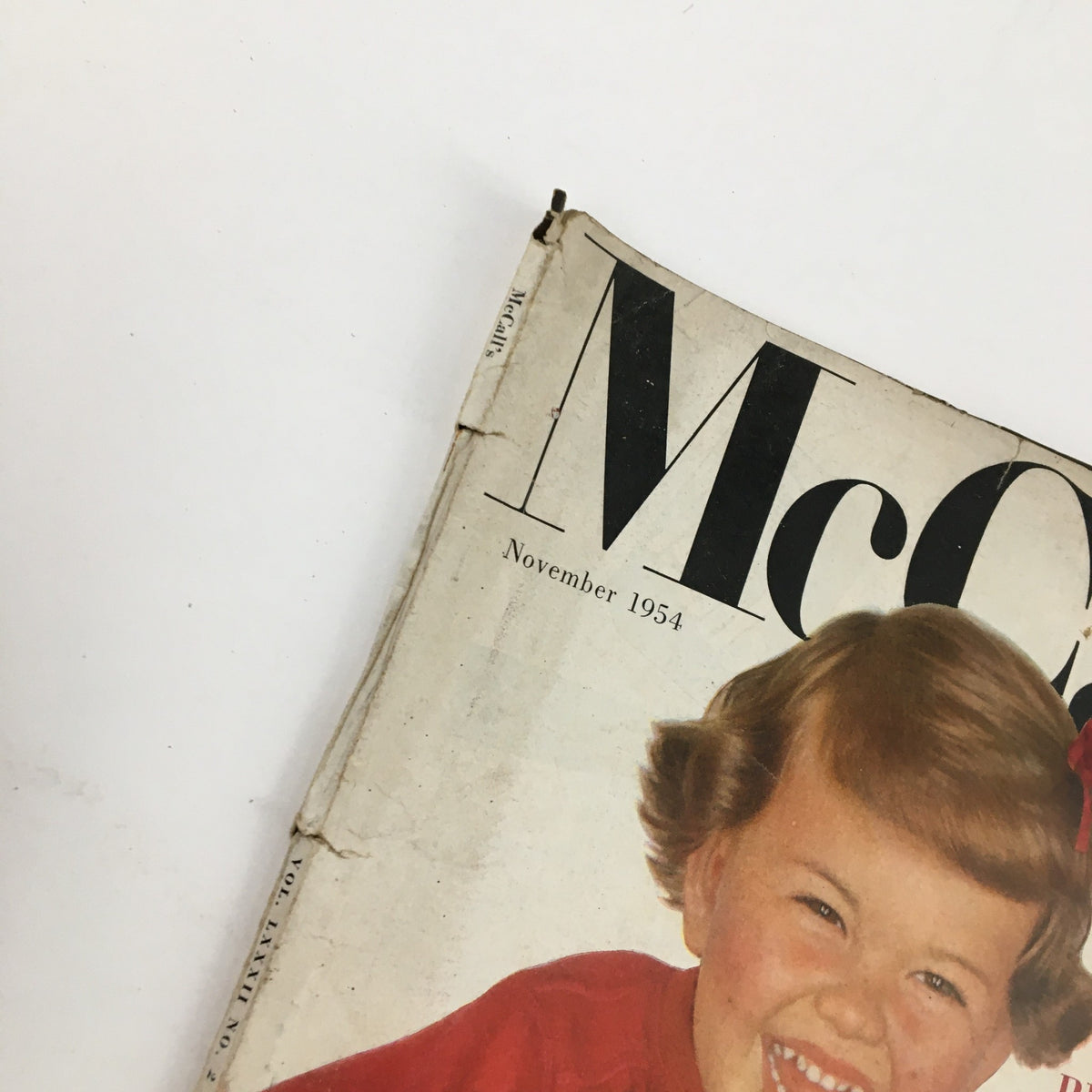 Top view of McCall's Magazine November 1954 cover featuring a smiling child in a red shirt, showcasing the magazine's nostalgic appeal.