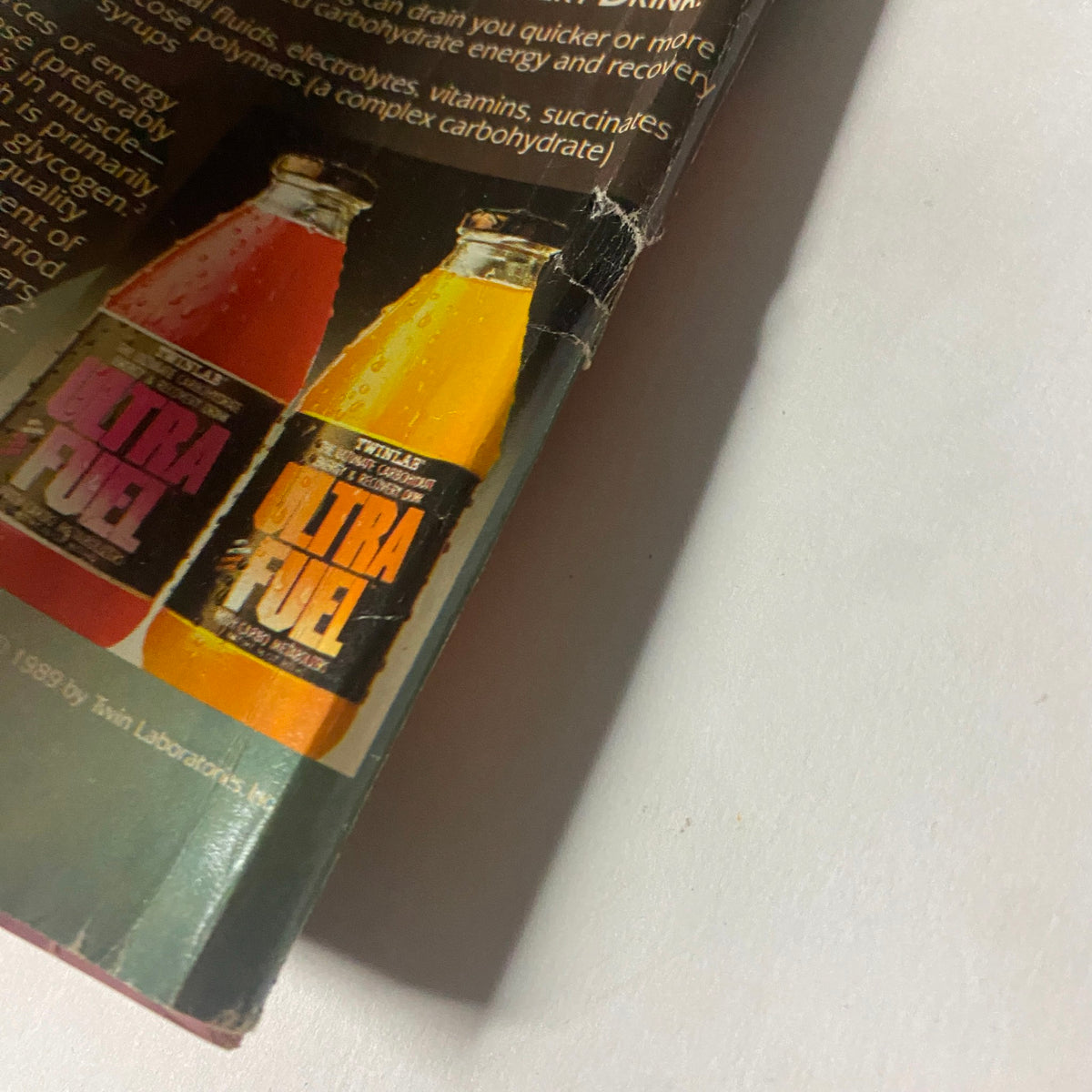 Close-up of an advertisement in Muscle Training Illustrated January 1990 for Ultra Fuel beverages, featuring two flavors and emphasizing quick energy and recovery.
