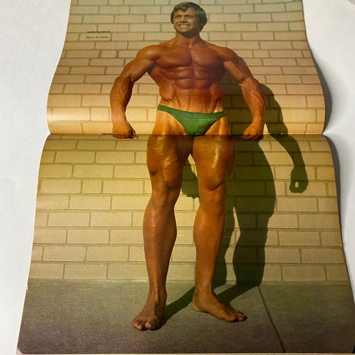 Centerfold from Muscle Training Illustrated 1982 showcasing a muscular male bodybuilder in a green posing brief, highlighting the classic bodybuilding aesthetics.