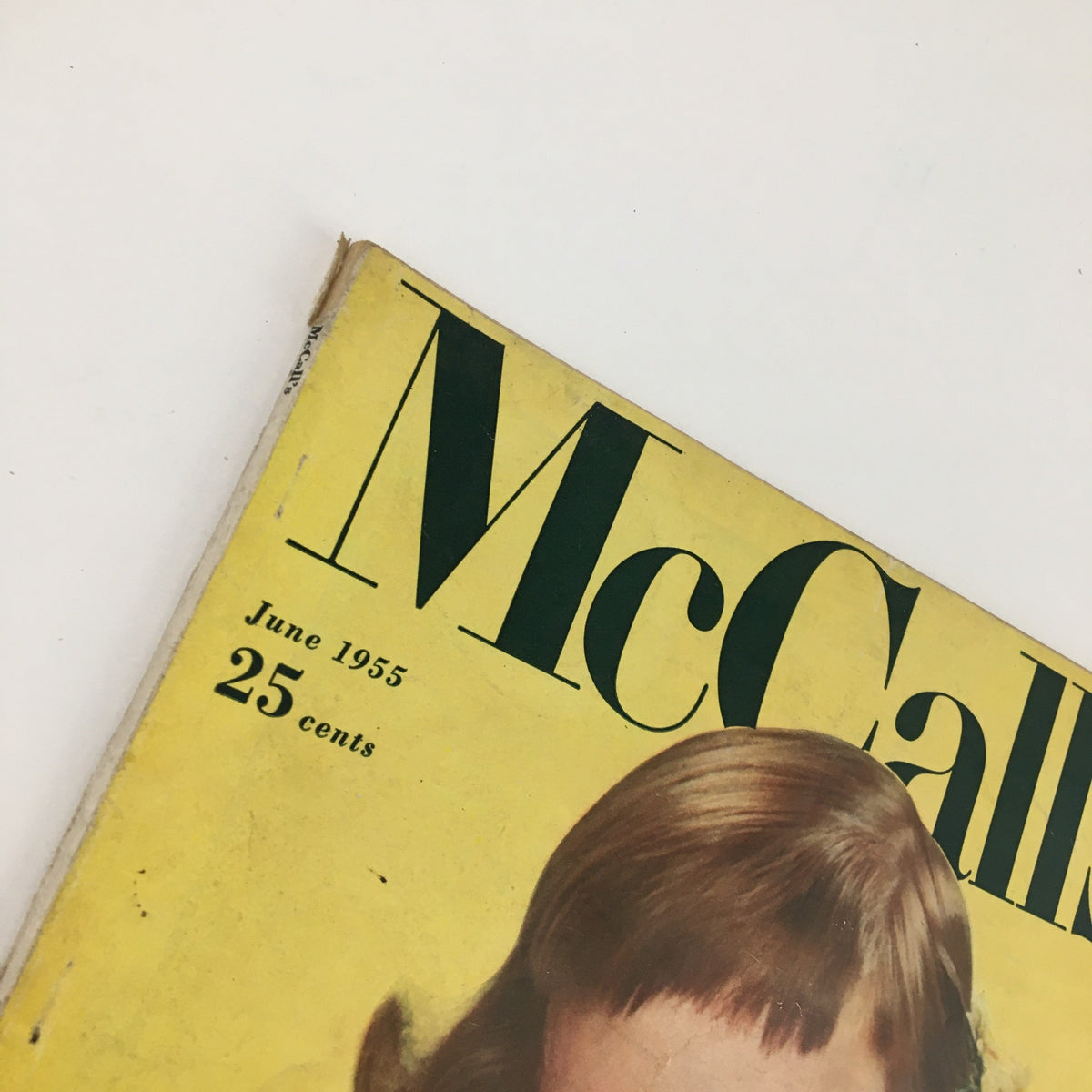 Cover of McCall's Magazine June 1955 featuring vintage design elements and model Sheila Burkhardt, selling for 25 cents.