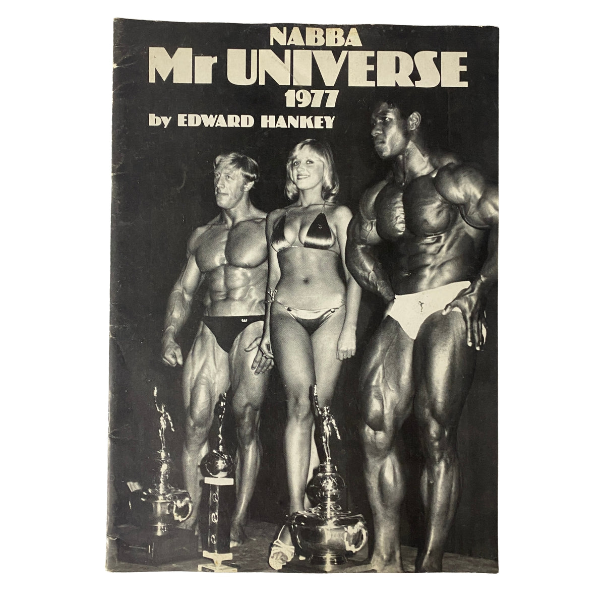 Cover of the 1977 NABBA Mr. Universe program by Edward Hankey featuring competitors and trophies.