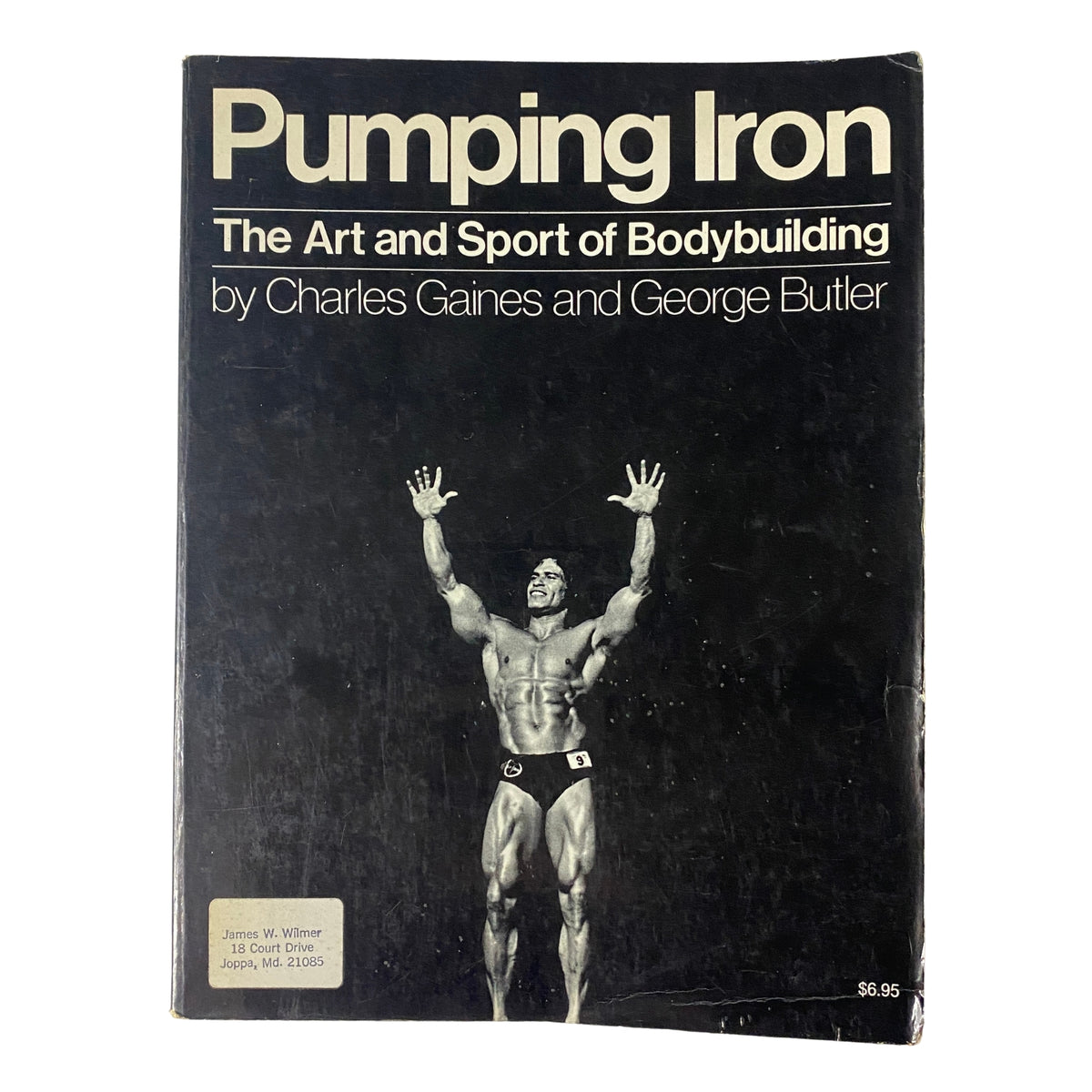 Cover of 'Pumping Iron: The Art and Sport of Bodybuilding' by Charles Gaines and George Butler, featuring a muscular bodybuilder posing in a classic bodybuilding stance.