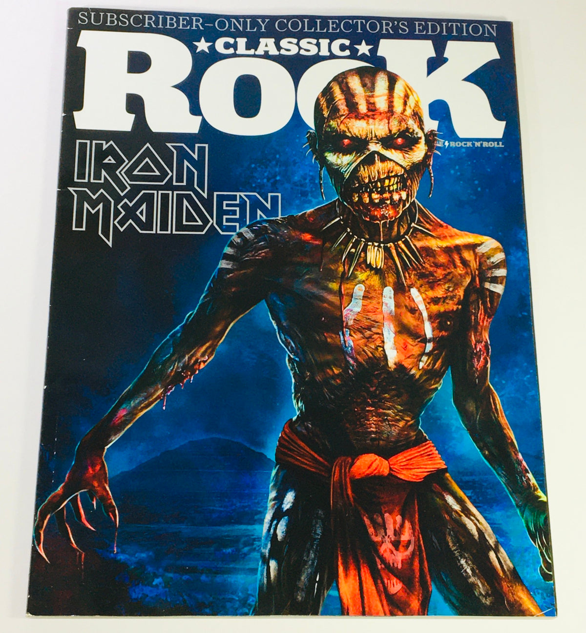 Classic Rock Magazine October 2015 #215 featuring Iron Maiden cover art with a striking illustration of a zombie-like figure, showcasing intricate details and vibrant colors. This collectible issue highlights significant figures in rock history.