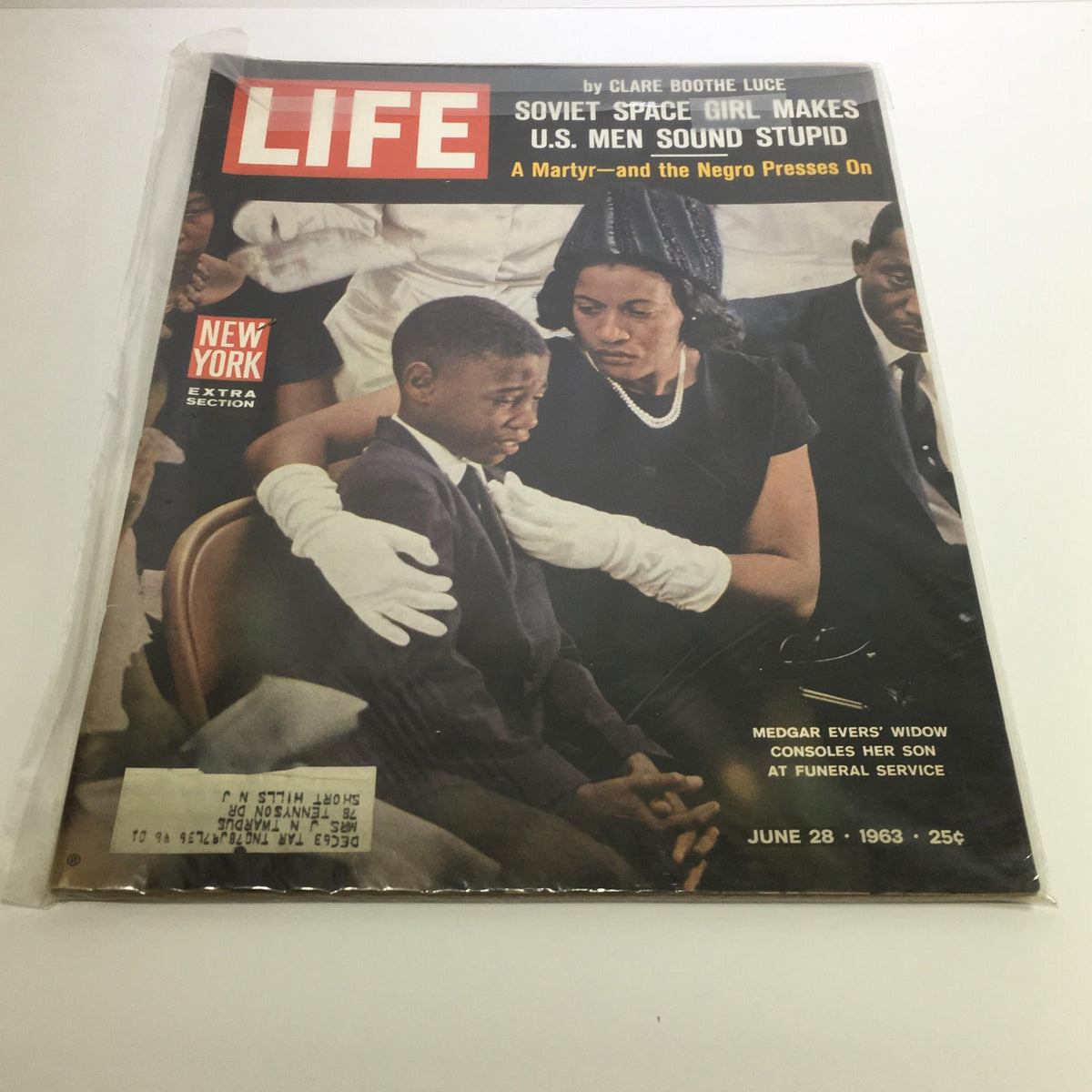 Life Magazine Cover from June 28, 1963 featuring a poignant scene depicting Medgar Evers' widow consoling her son at his funeral service. Title: 'A Martyr - And The Negro Presses On' featuring significant themes of the civil rights movement.