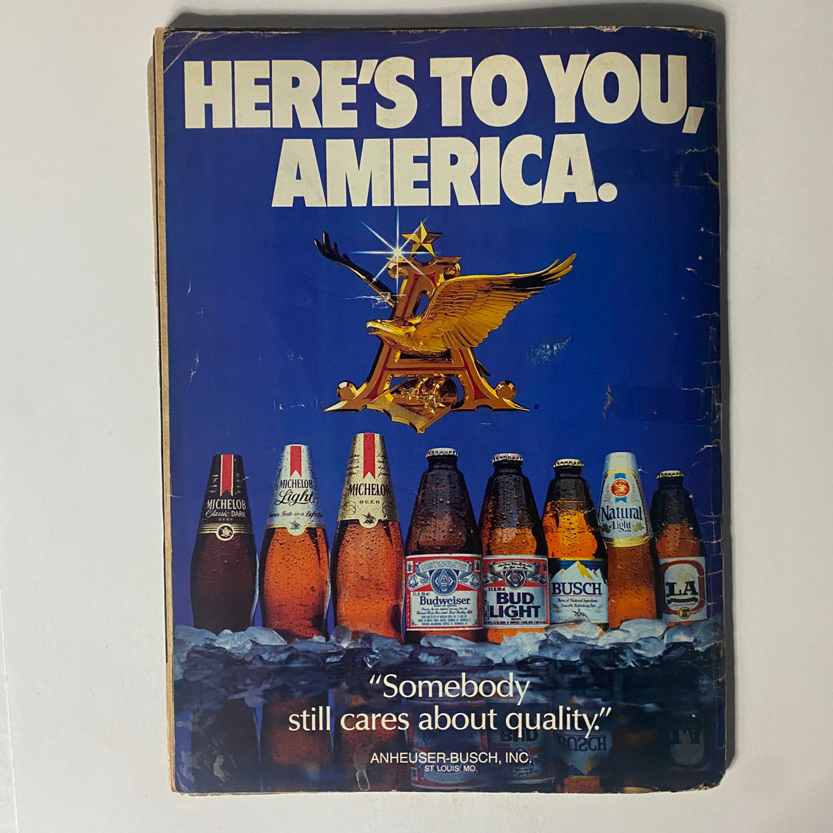 Back cover of Wrestling Eye Magazine November 1985 with an advertisement featuring various beer brands and the phrase 'Here's to You, America'.