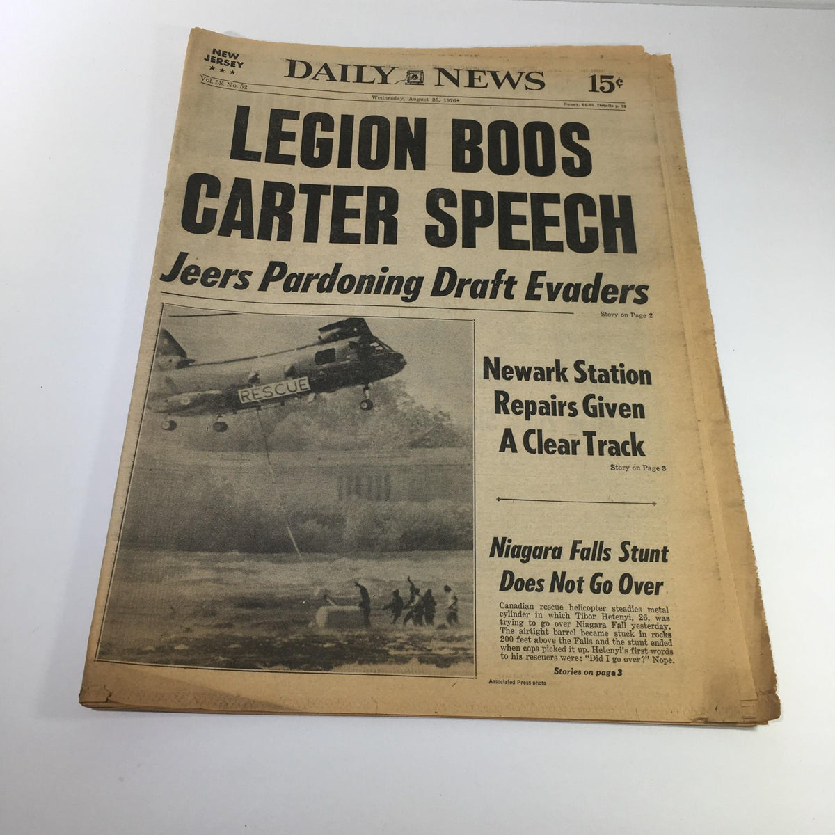 NY Daily News from August 25, 1976: Front page featuring headline 'LEGION BOOS CARTER SPEECH; Jeers Pardoning Draft Evaders' with image of a helicopter rescue.