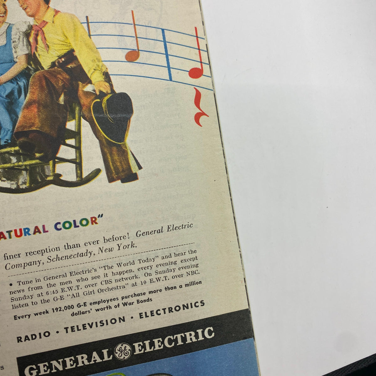 Advertisement for General Electric from January 29, 1944, promoting enhanced reception, featuring a couple in a colorful scene with musical notes.