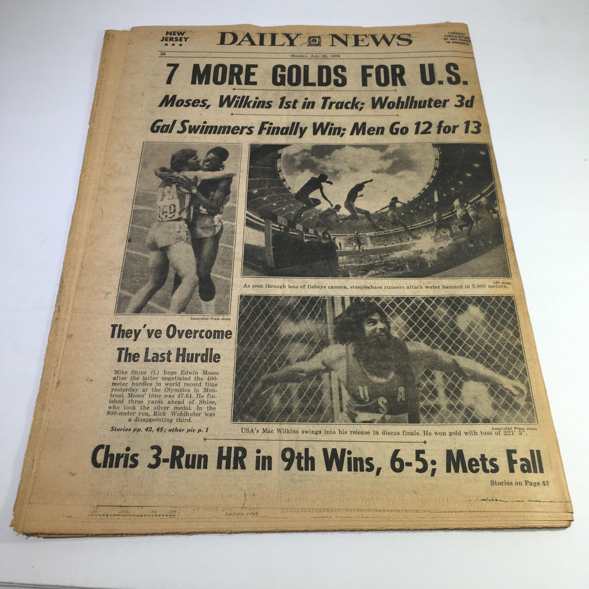 Vintage newspaper cover from NY Daily News dated 7/26/76, featuring the headline '7 MORE GOLDS FOR U.S.' including highlights of the Olympics, track and swimming events, and notable sports achievements. Reflects the excitement of the 1976 Olympic Games.