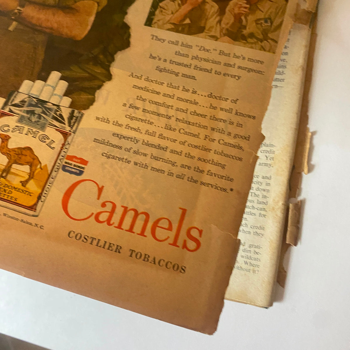 Close-up of an advertisement from VTG Collier's Magazine, May 13, 1944, showcasing Camel cigarettes with a focus on a soldier discussing medical support in wartime.