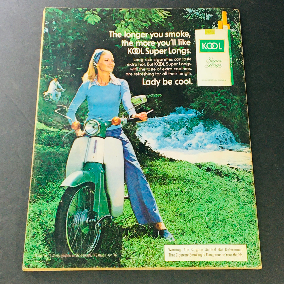 Photoplay Magazine November 1976 advertisement for Kool Super Longs cigarettes featuring a model on a scooter in a natural setting.