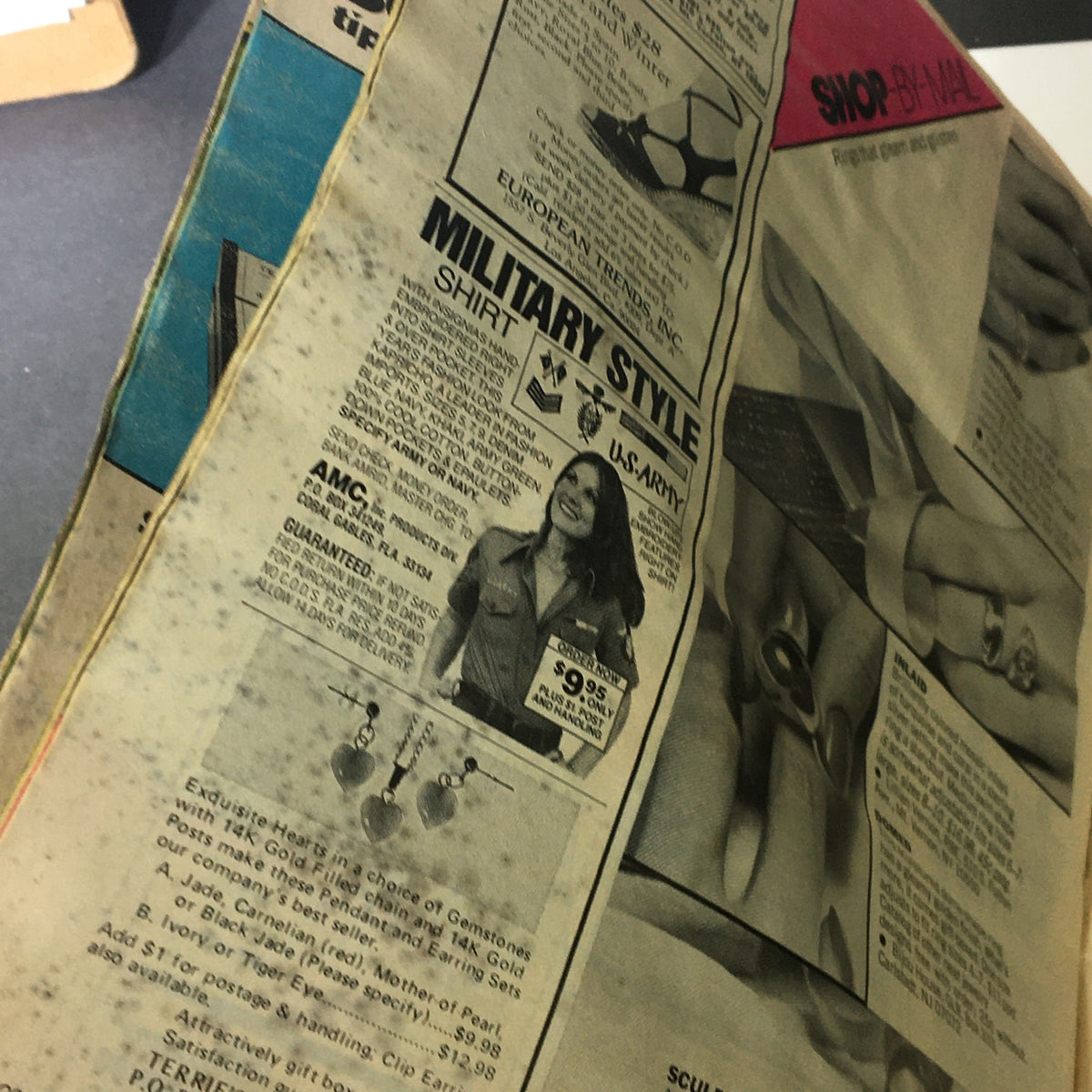 Page from Vintage Glamour Magazine August 1977 displaying vintage advertisements for military-style shirts, featuring a model and various products.