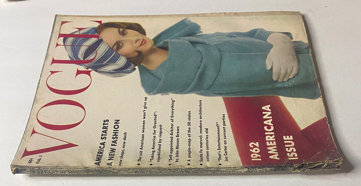 Vogue Magazine cover dated February 1, 1962 showcasing model Wilhelmina Cooper in a green coat with white gloves and a striped headscarf, promoting the content 'America Starts a New Fashion' and titled '1962 Americana Issue'.