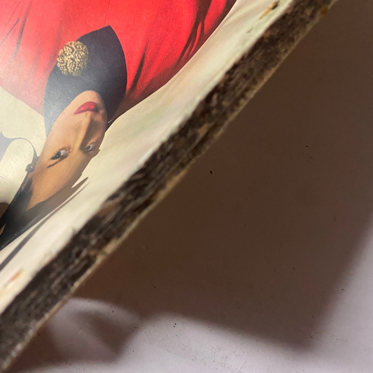 Close-up of the spine of Vogue Magazine March 15, 1947, highlighting the wear and tear on the edges, emphasizing its vintage character.