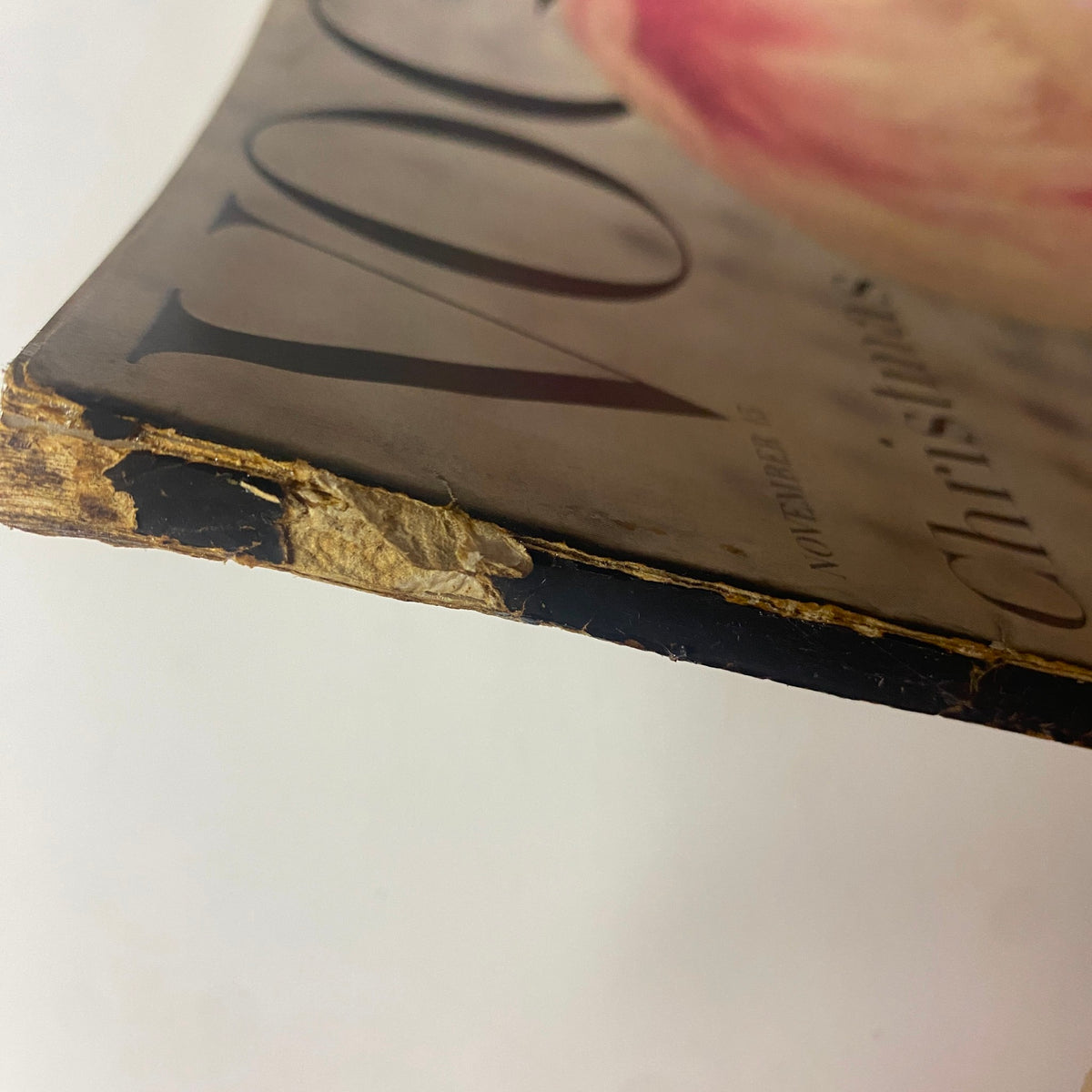 Close-up of the spine of Vogue Magazine November 15, 1955. This image highlights the vintage wear with slight tears and age-related patina, showcasing the magazine's historical significance.