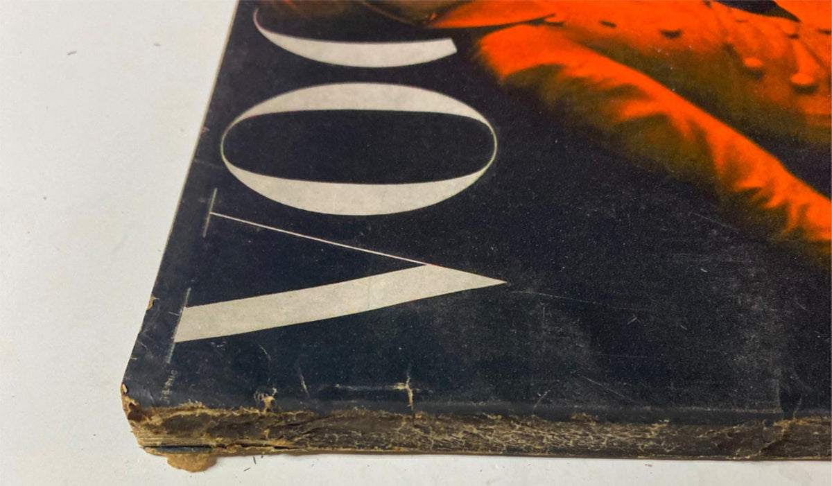 Close-up view of the bottom edge of the September 15, 1947 Vogue Magazine showcasing the magazine title 'Vogue.' The image captures the aged spine and evidence of use, reflective of its vintage status.