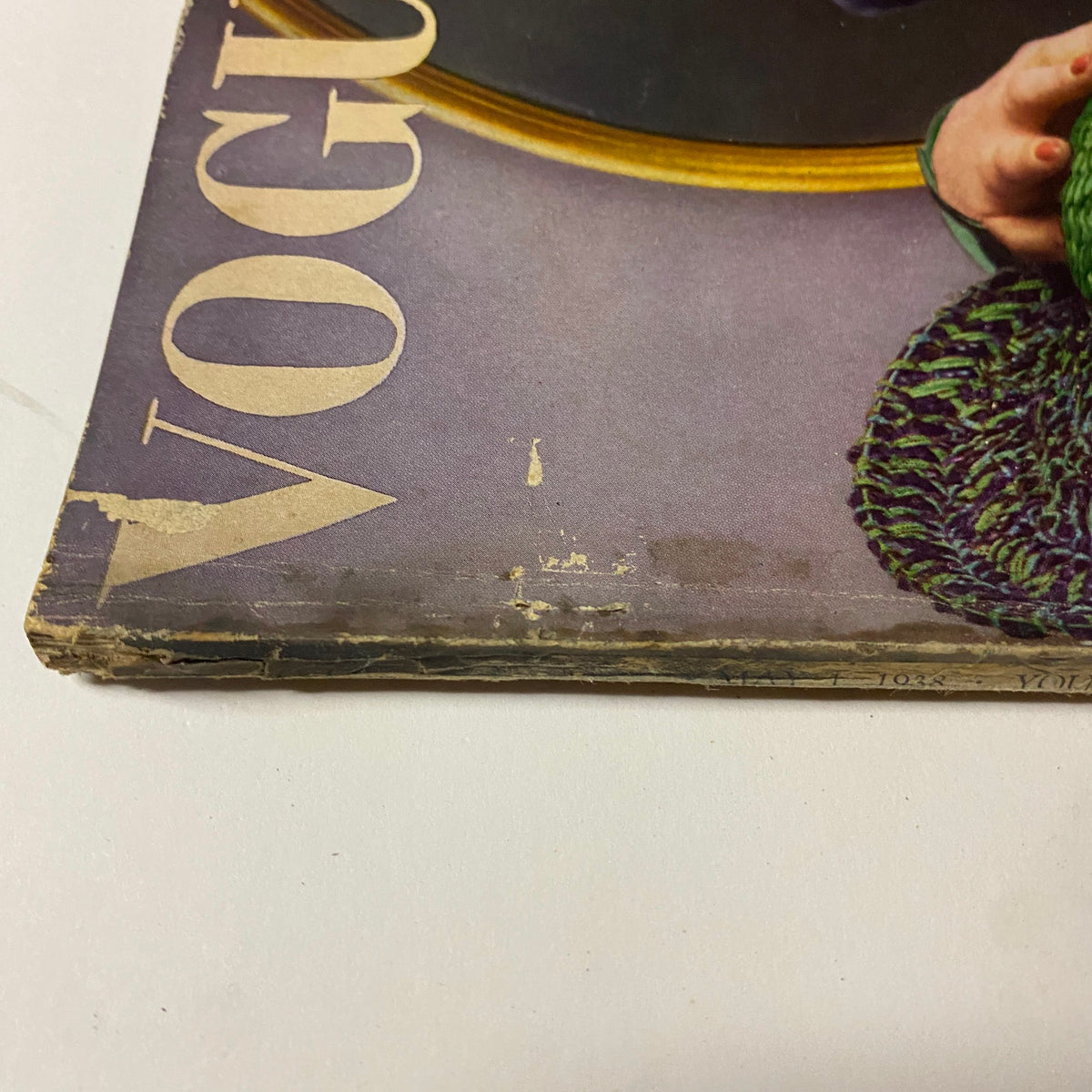 Close-up of the corner and edge wear of the Vogue Magazine May 1, 1938 Cover by Anton Bruehl, highlighting creases and surface damage.