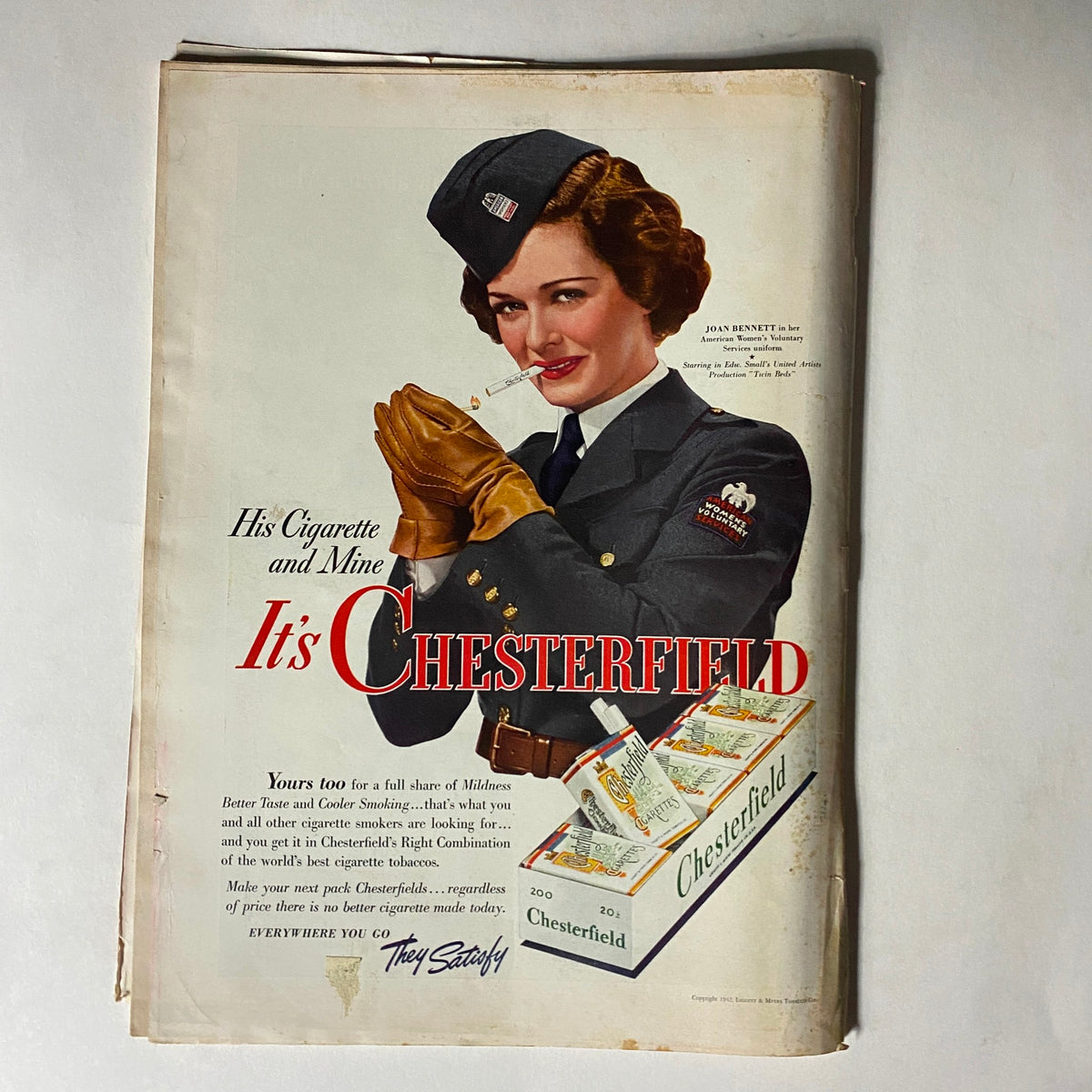 Advertisement from a vintage Time Magazine dated March 30, 1942 showcasing Chesterfield cigarettes with a woman in uniform holding a cigarette, emphasizing cigarette advertising styles of the era.