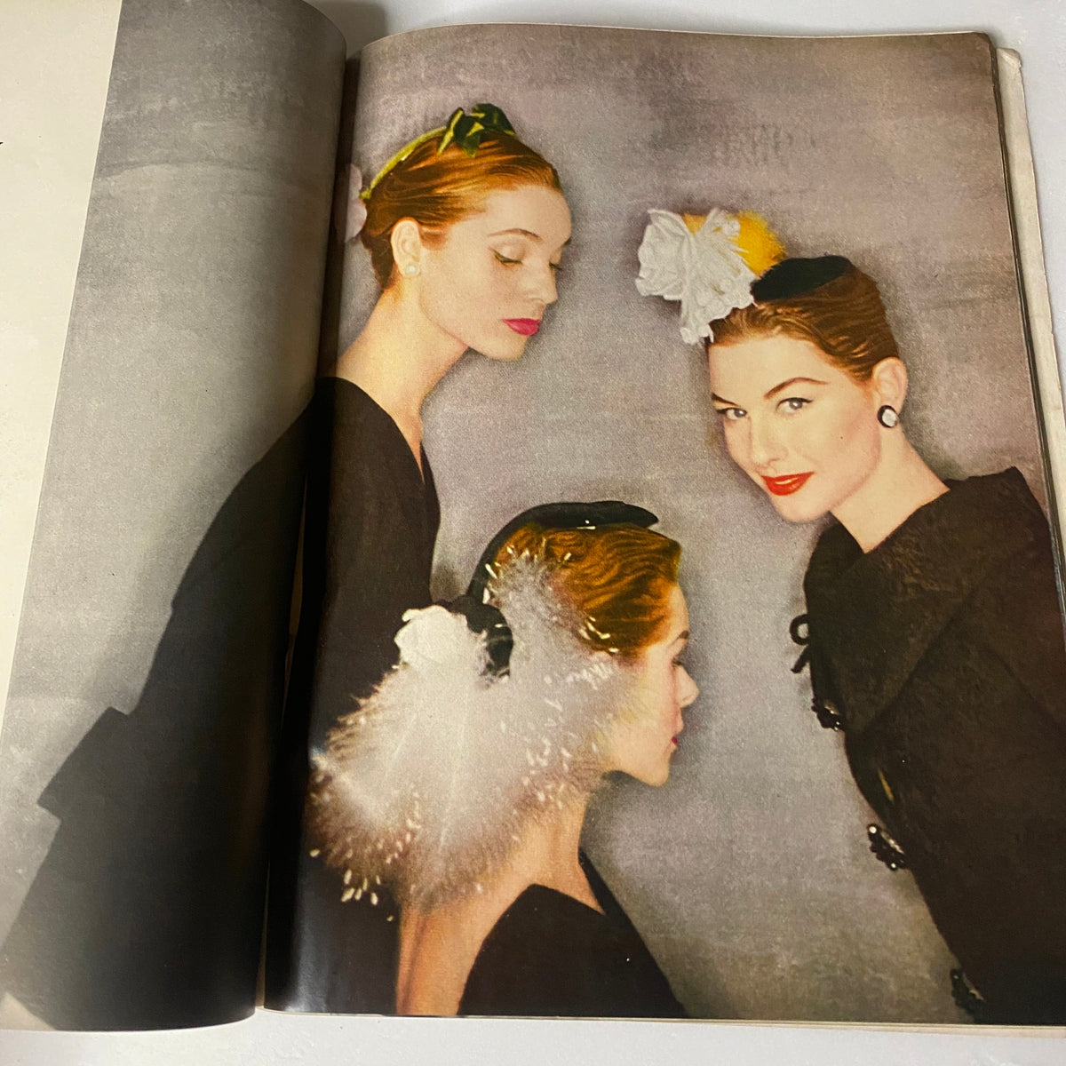Vogue Magazine October 1, 1954 interior page featuring three models styled with exquisite hats, highlighting fashion photography by Horst P. Horst.