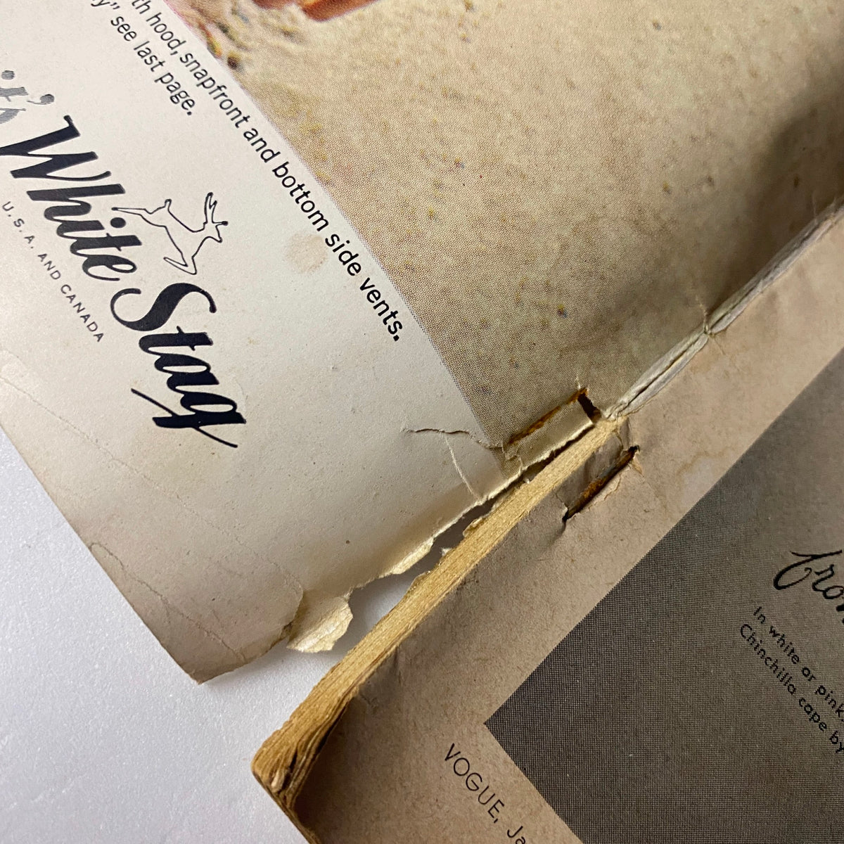 Close-up of a damaged section of Vogue Magazine January 15, 1964, highlighting the wear and tear typical of vintage magazine issues.