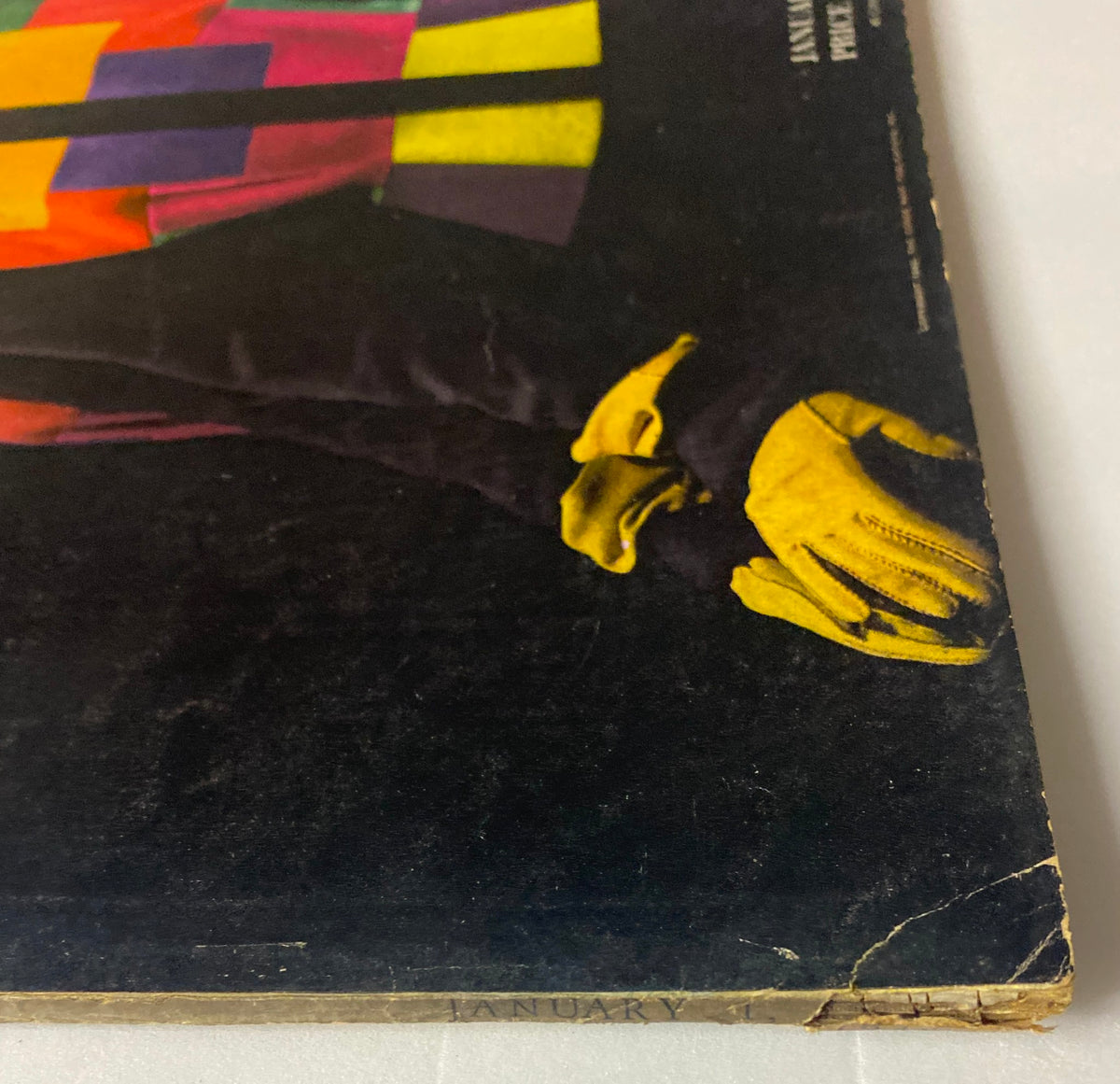 Side view of the Vogue Magazine January 1, 1944 cover, showcasing the model's vibrant jacket and gloves, along with details of the magazine's date and price.