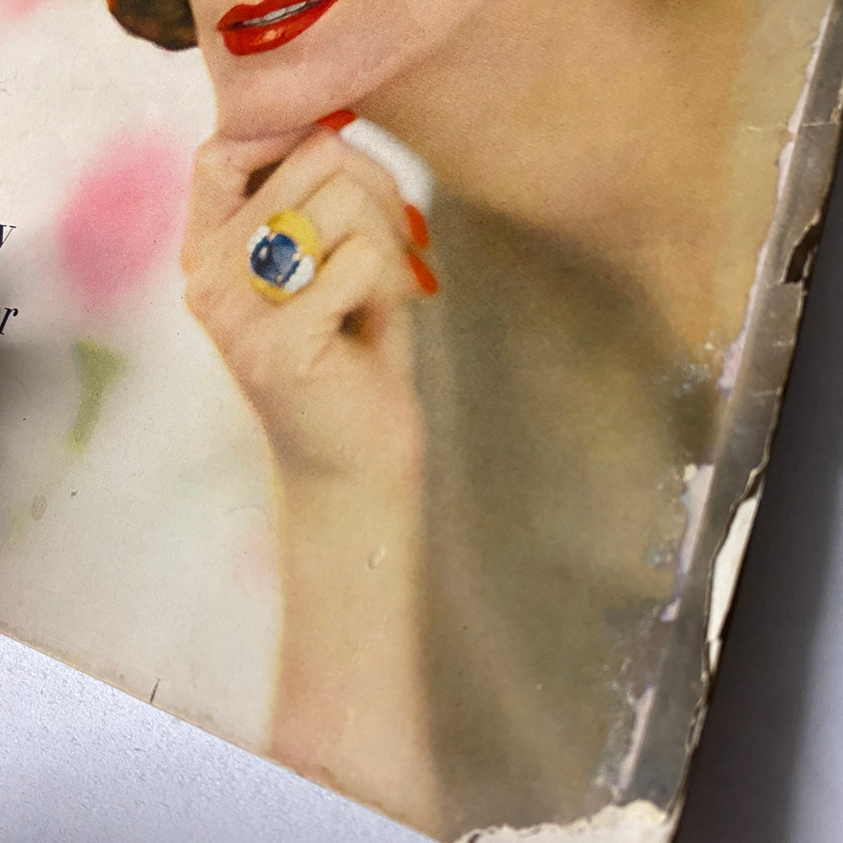 Close-up detail of the cover of Vogue Magazine February 15, 1957 featuring Anne St. Marie, emphasizing her elegant ring and classic red lips, encapsulating 1950s fashion.