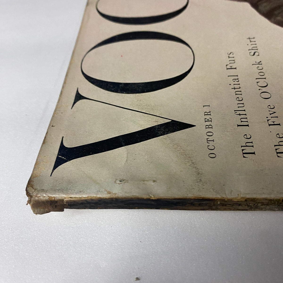 Close-up view of the October 1, 1954 Vogue Magazine cover, showing the magazine title and details, focusing on its vintage charm and design.