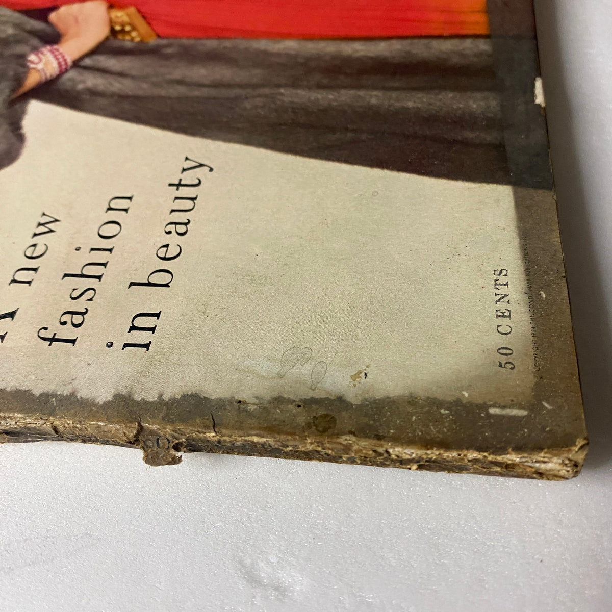 Detailed image of the spine and edge of the October 1, 1954 Vogue Magazine, illustrating its age and authenticity along with model Jean Patchett's fashion cover.