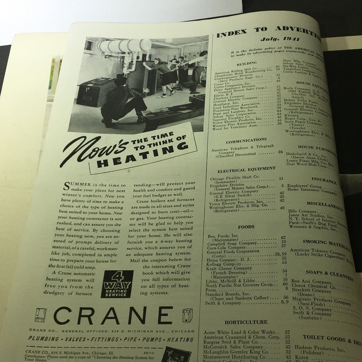 Interior page of VTG The American Home July 1941 showing an advertisement for heating services with a vintage photograph of people in a showroom.