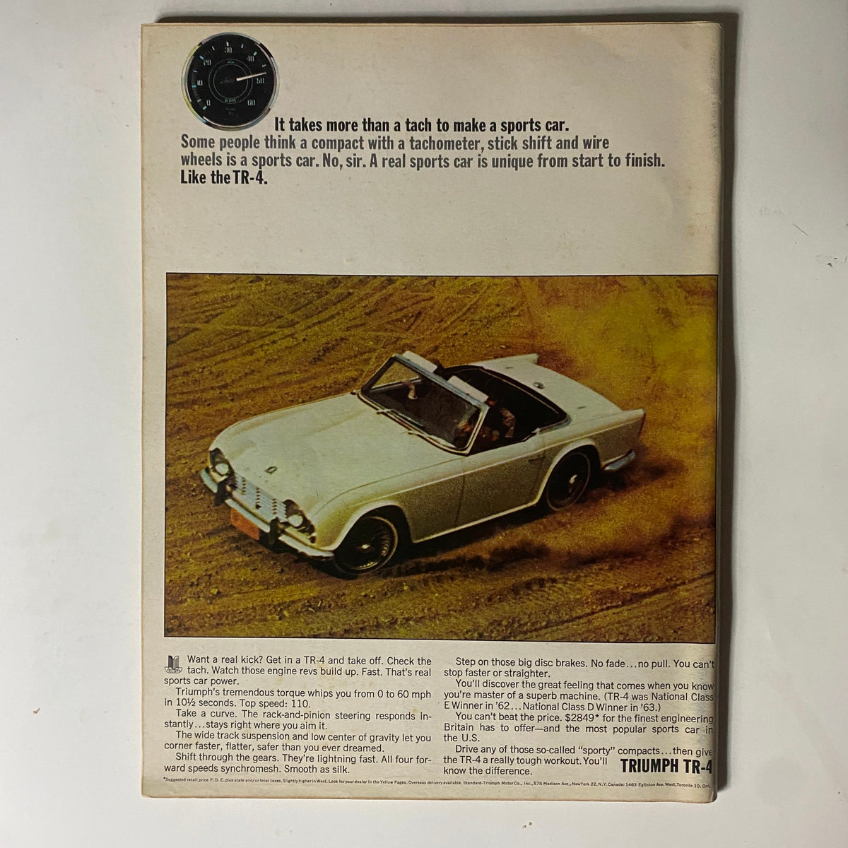 Back cover of the December 1964 Car and Driver magazine featuring a Triumph TR-4 sports car advertisement, showcasing its unique features and performance specifications. The ad emphasizes the car's agility and handling, appealing to automotive enthusiasts.