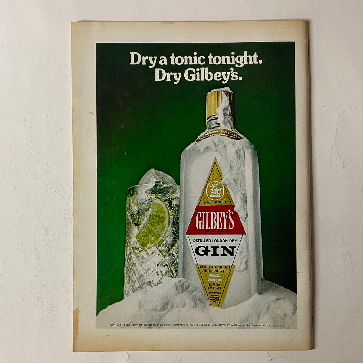 Vintage advertisement for Gilbey's Gin from The New Yorker Full Magazine July 22, 1974, showcasing a bottle of gin with a glass of tonic and a green background.
