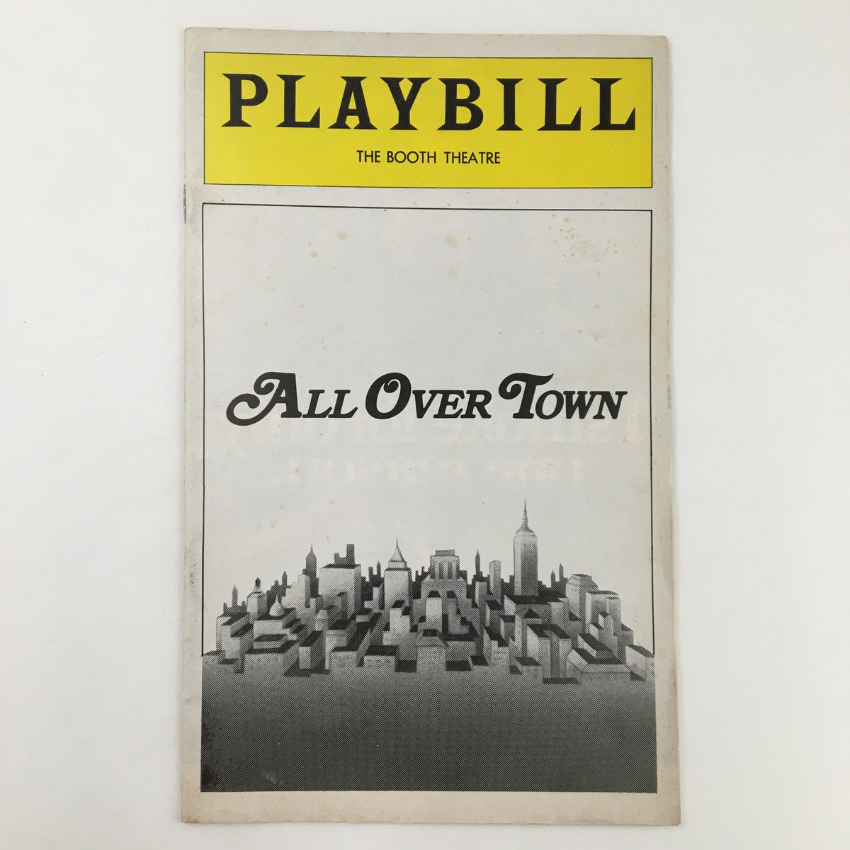 1975 Playbill for The Booth Theatre featuring the title 'All Over Town', showcasing a skyline design representing New York City.