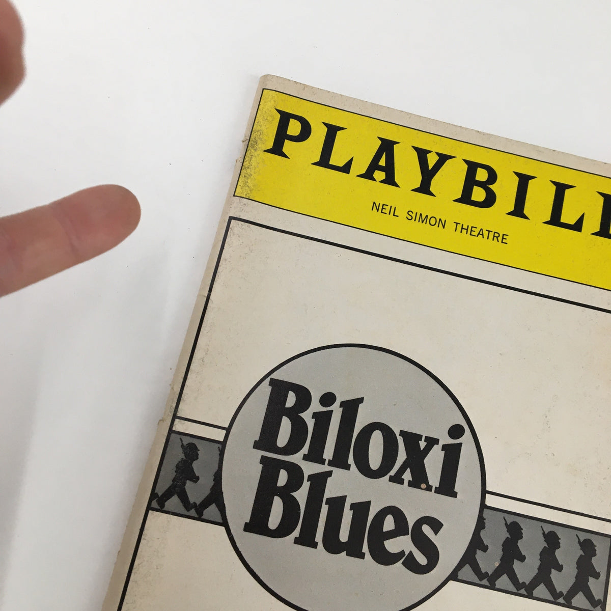 Close-up view of the 1985 Playbill for Biloxi Blues, highlighting the title and vintage wear on the cover.