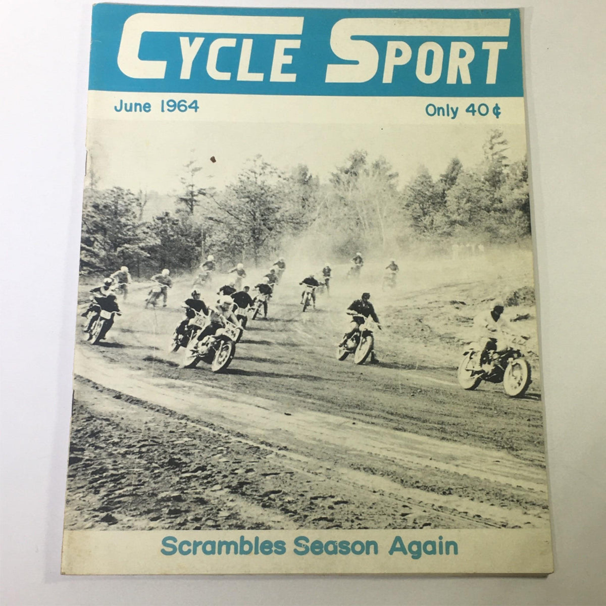 Cover of VTG Cycle Sport Magazine June 1964 showcasing a thrilling scrambles racing scene with multiple motorcycles on a dirt track, emphasizing the excitement of the scrambles season.