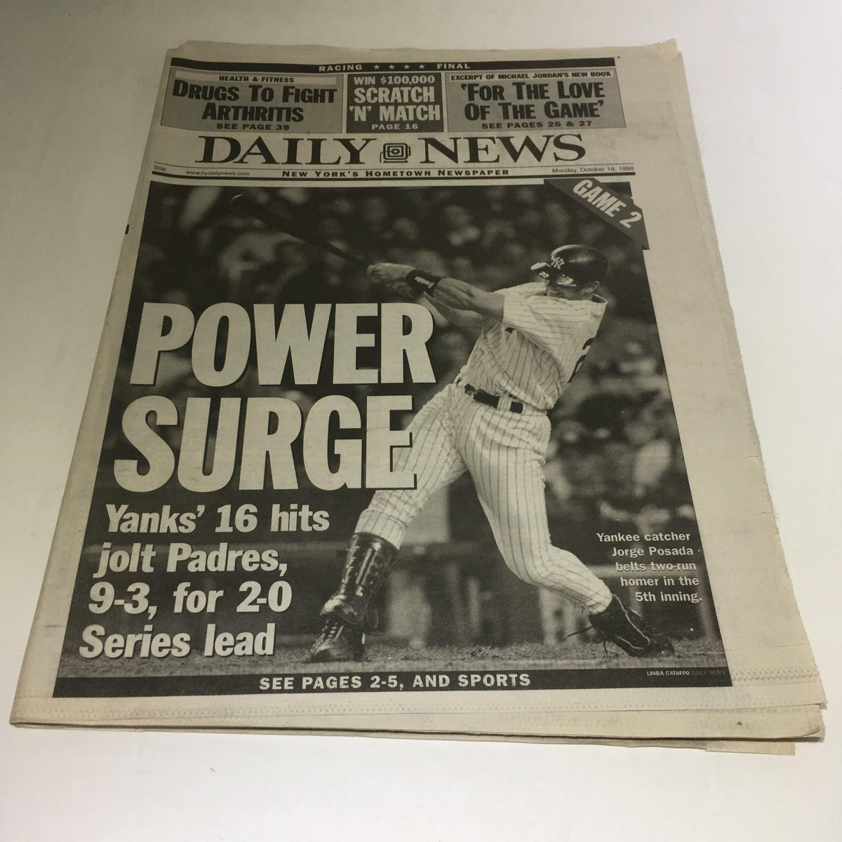 Front page of NY Daily News featuring the headline 'Power Surge' celebrating the New York Yankees' victory in Game 2 of the World Series on October 19, 1998. The image highlights a key moment with the Yankees player in action.