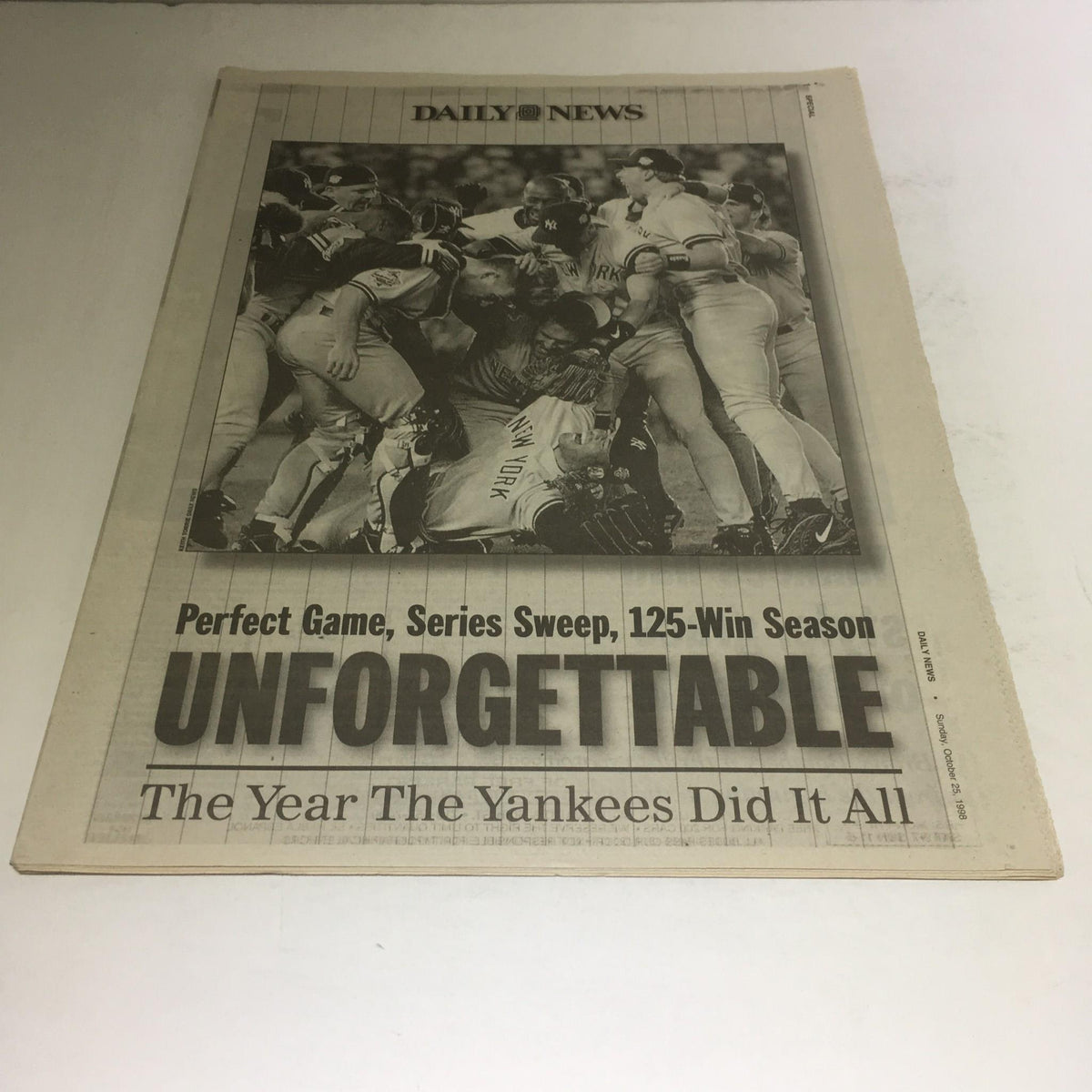 Vintage NY Daily News from October 25, 1998, featuring the headline 'Perfect Game, Series Sweep, 125-Win Season - Unforgettable', depicting a celebration moment of the New York Yankees.